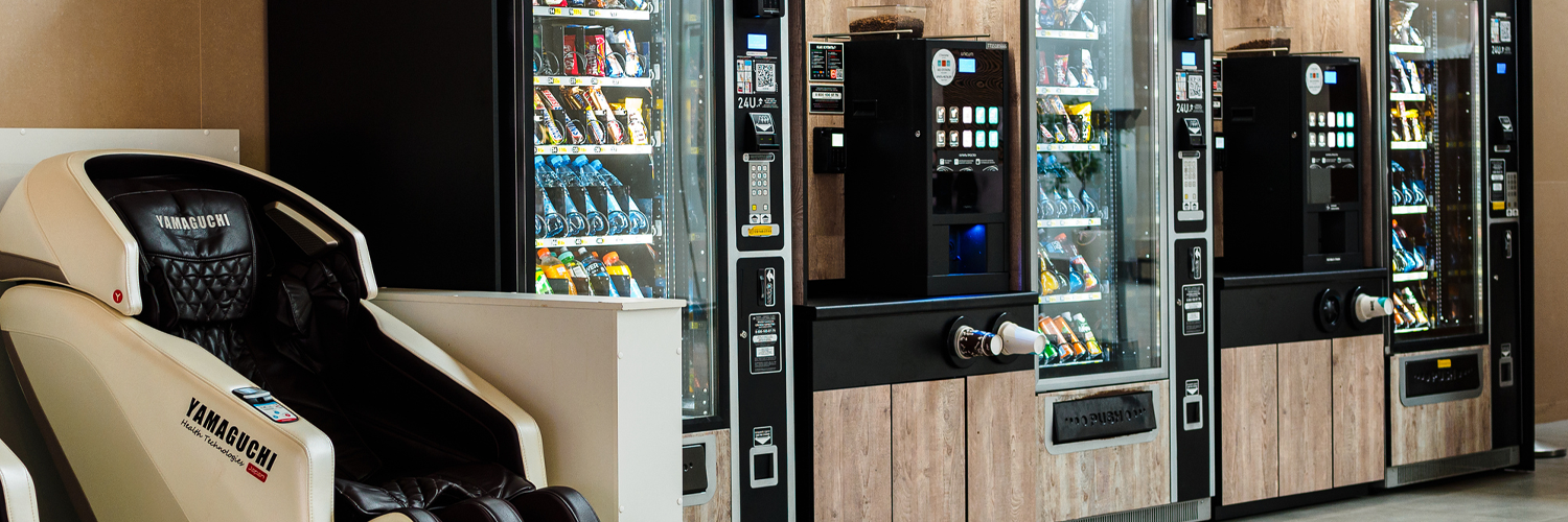 Boost vending machines revenue with equipped with cashless payment readers beside a massage chair, showcasing an upgraded self service setup.