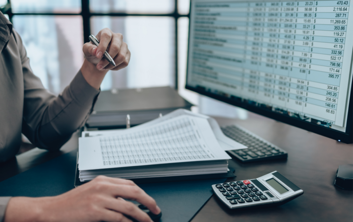 Accounting professional reviewing financial reports and transaction data on a computer for accurate reconciliation and tax preparation.