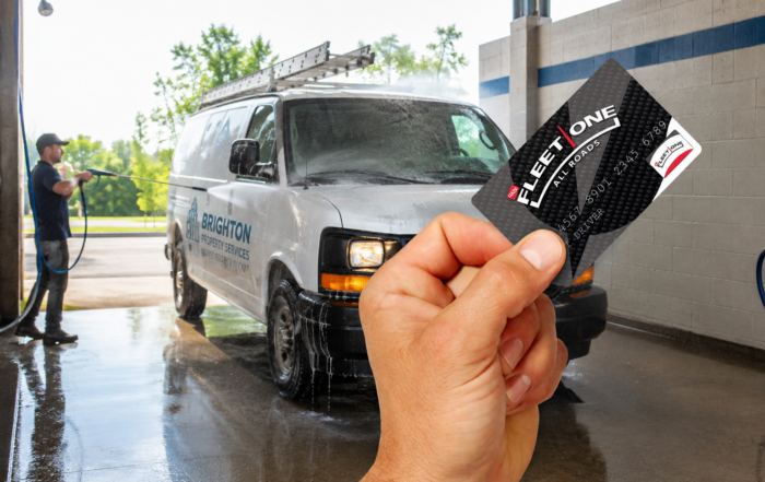Car wash fleet card payments represented by a fleet card held in front of a commercial van at a self-service car wash.